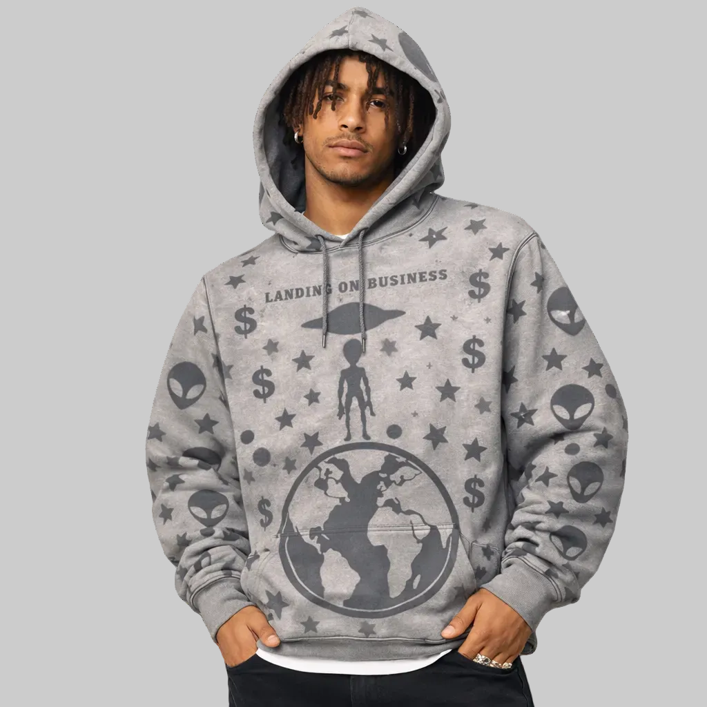 Person wearing a gray hoodie with alien and dollar sign patterns on a white background