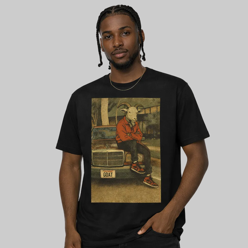 Person wearing a black t-shirt with a graphic design of a person with goat head sitting on a car.