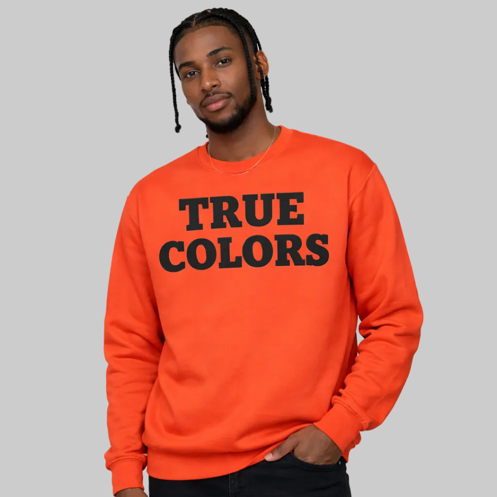 Person wearing an orange sweatshirt with 'TRUE COLORS' text on a white background