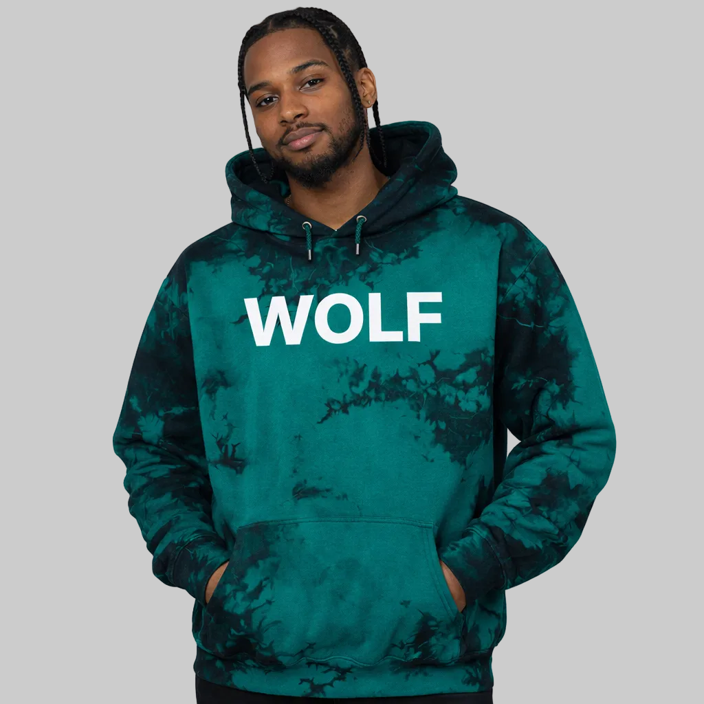 Man wearing a green tie-dye hoodie with 'WOLF' printed on it against a gray background