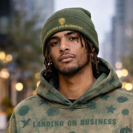 Man wearing a green hoodie with graphic designs on a city street