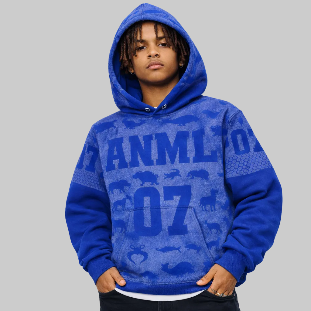 Child wearing a blue hoodie with text and animal patterns on a white background