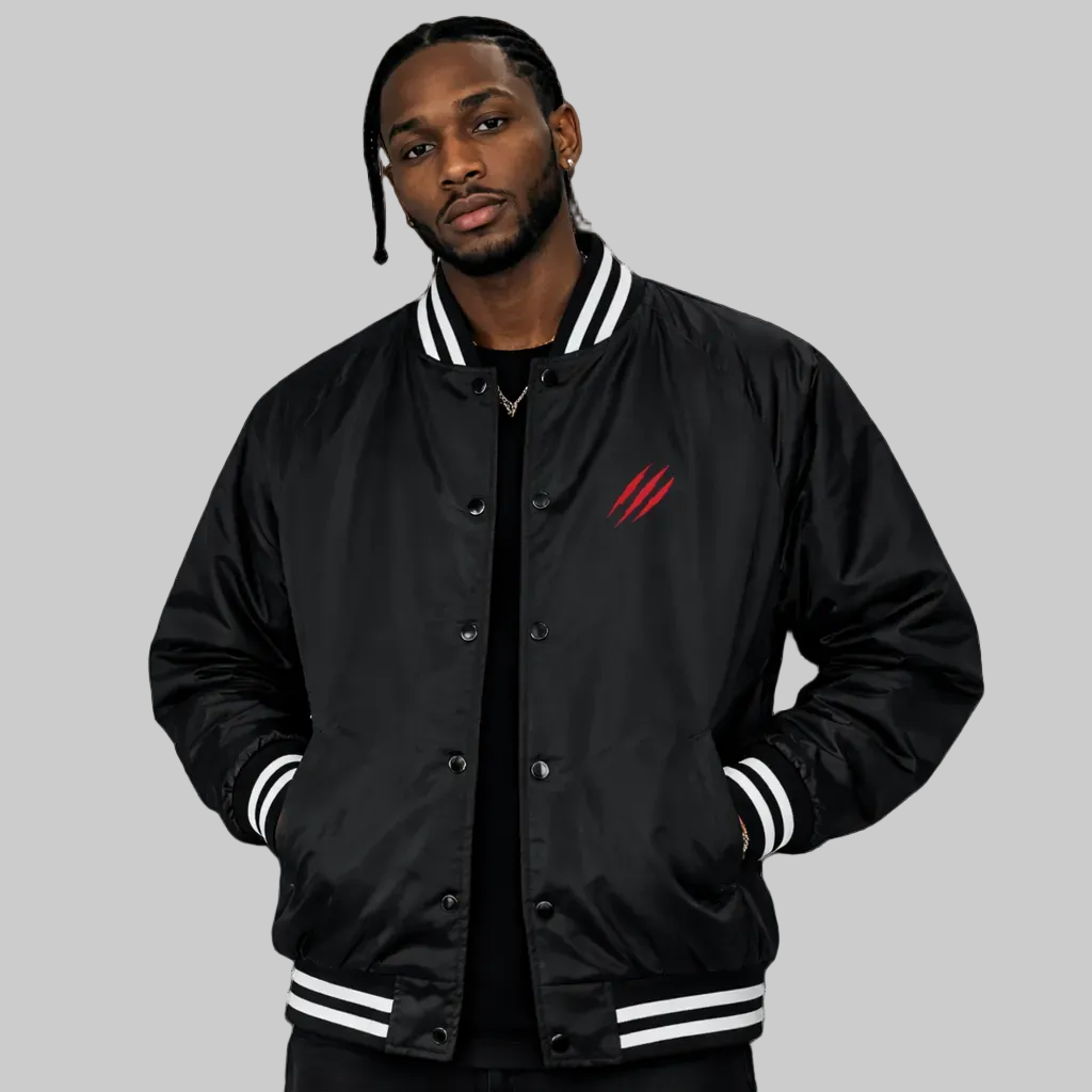 Person wearing a black varsity jacket with a red logo on a white background